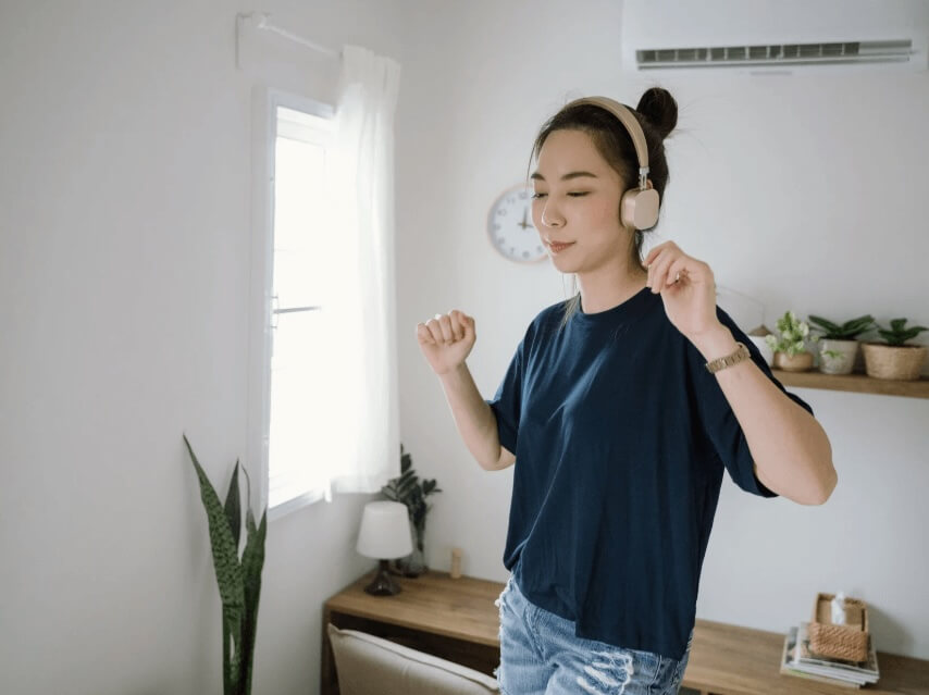 Young woman dancing in a bedroom.